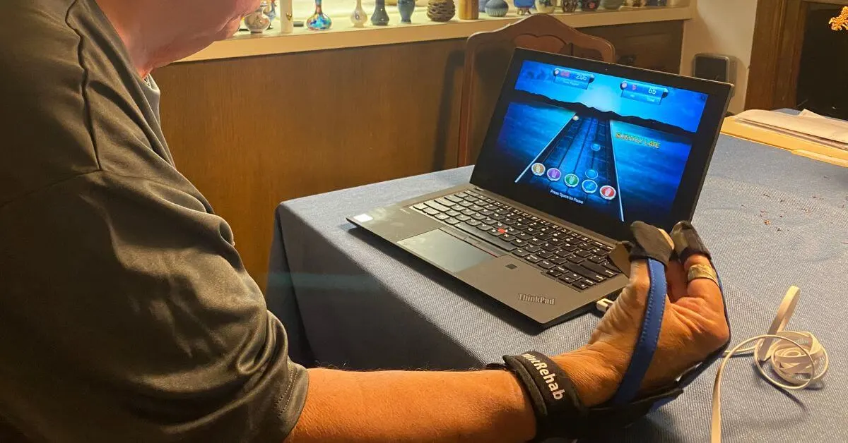man using physical therapy tools for hands called the musicglove