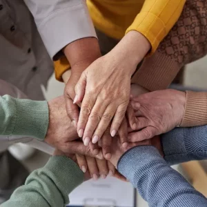 survivors from a stroke support group putting hands in