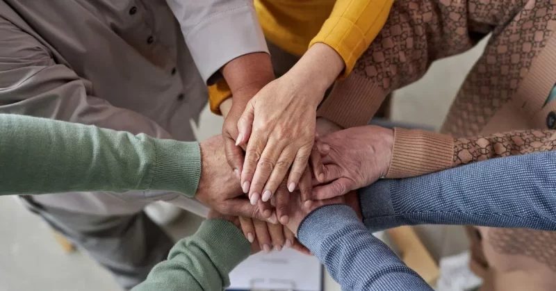 survivors from a stroke support group putting hands in