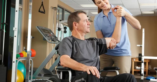 man recovering after spinal cord injury doing rehab with a therapist
