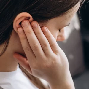 woman with hyperacusis after brain injury holding her ears