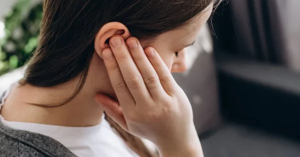 woman with hyperacusis after brain injury holding her ears
