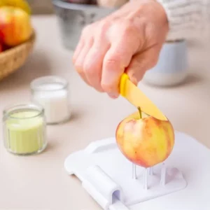 man using adaptive kitchen tool to cut an apple