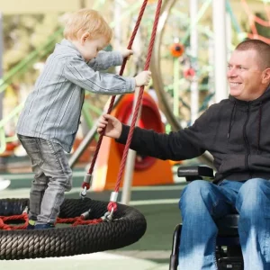 man playing with his son and daughter after a spinal cord injury